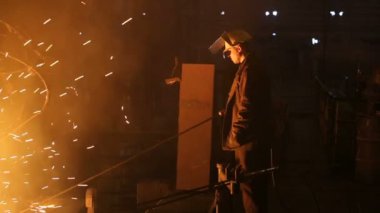 Çelik üretimi için bitki. Elektrikli bir eritme fırını. Fabrika işçisi metal için örnek alıyor.