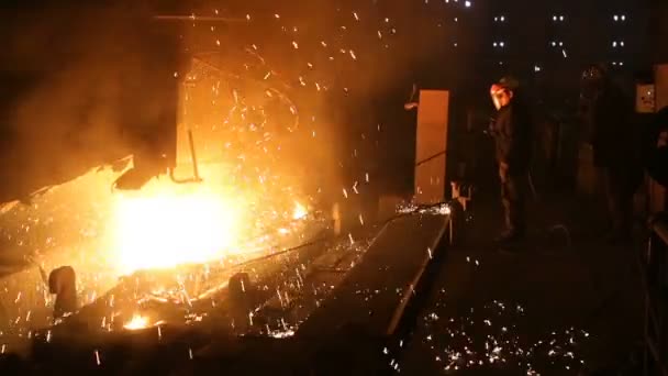 Завод з виробництва сталі. Електрична піч для плавлення. Заводський робітник бере зразок для металу — стокове відео