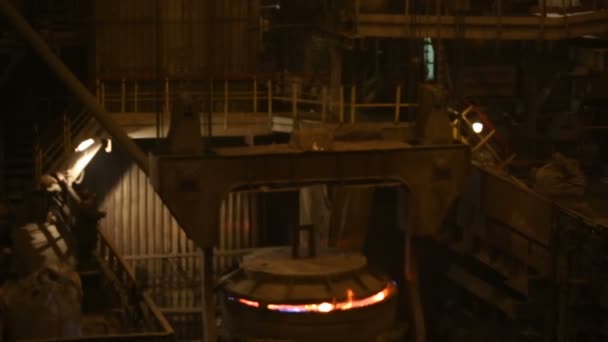 강철 생산을 위한 식물. 전기가 녹는 용광로. 공장에서 일하는 사람이 금속 샘플을 채취 한다 — 비디오