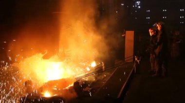 Çelik üretimi için bitki. Elektrikli bir eritme fırını. Fabrika işçisi metal için örnek alıyor.