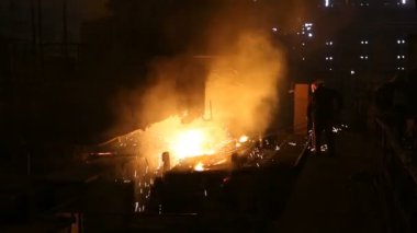 Çelik üretimi için bitki. Elektrikli bir eritme fırını. Fabrika işçisi metal için örnek alıyor.