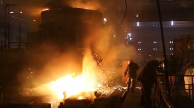 Çelik üretimi için bitki. Elektrikli bir eritme fırını. Fabrika işçisi metal için örnek alıyor.