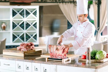 Aşçı bir adam lokantada bıçakla et keser..