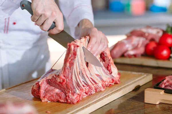 Aşçı bir adam lokantada bıçakla et keser.. — Stok fotoğraf