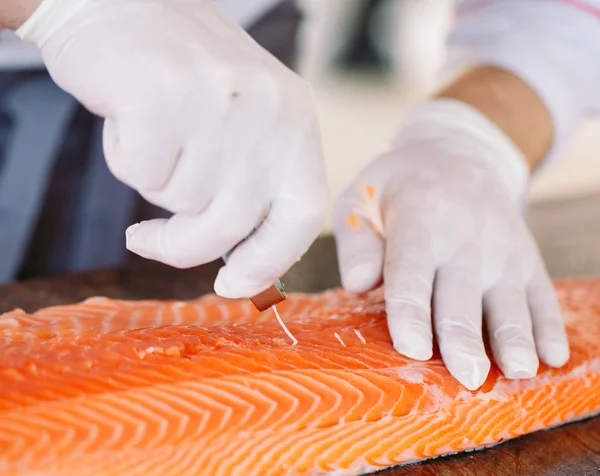 O chef corta o salmão na mesa . — Fotografia de Stock