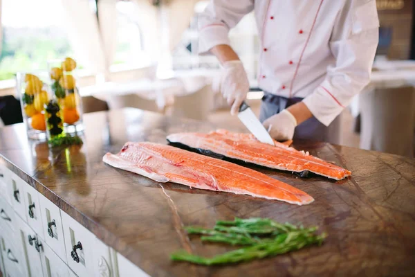 O chef corta o salmão na mesa — Fotografia de Stock