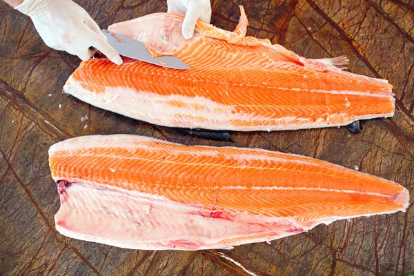 The chef cuts the salmon on the table — Stock Photo, Image