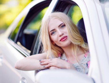 Genç güzel bir kız araba kullanıyor.