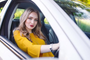 Genç güzel bir kız araba kullanıyor.