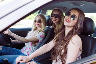 Üç genç kız bir arabada seyahat.