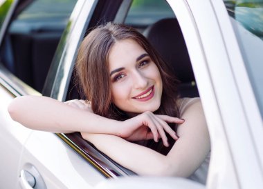 Genç güzel bir kız araba kullanıyor.