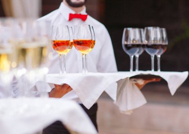 Zarif Garsonlar servis etmek için hazır bir kokteyl ile bir tepsi tutuyor.