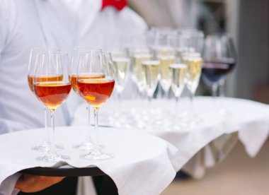 Zarif Garsonlar servis etmek için hazır bir kokteyl ile bir tepsi tutuyor.