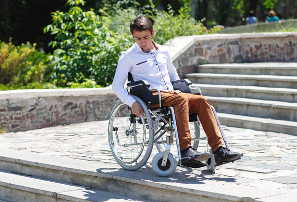 A young man in a wheelchair who can not descend the stairs.