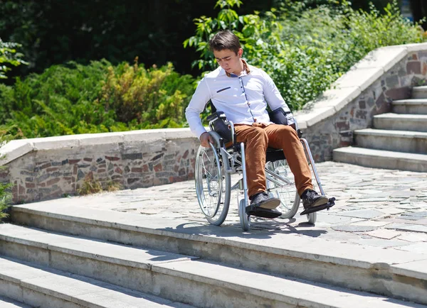 A young man in a wheelchair who can not descend the stairs. — Stock Photo, Image