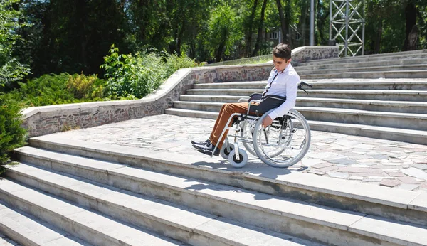 Un joven en silla de ruedas que no puede bajar las escaleras . —  Fotos de Stock