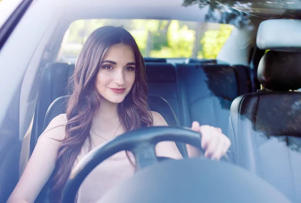 एक युवा सुंदर लड़की एक कार चला रही है . — स्टॉक फ़ोटो, इमेज