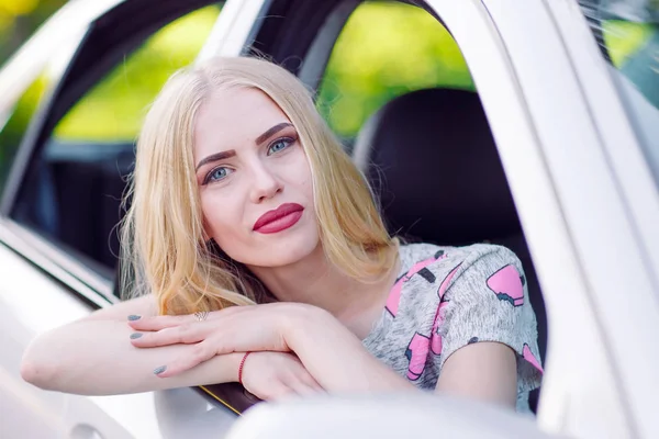 Una chica guapa joven está conduciendo un coche . — Foto de Stock