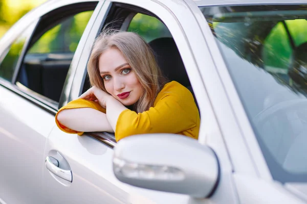 Una chica guapa joven está conduciendo un coche . — Foto de Stock