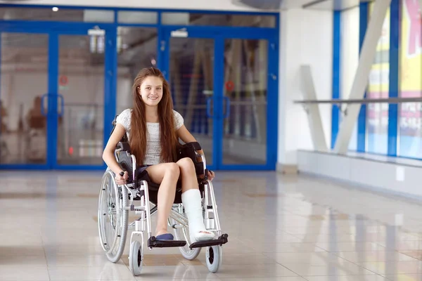 Uma jovem em uma cadeira de rodas está no corredor do hospital . — Fotografia de Stock