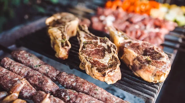 Grandes trozos de carne en escabeche en una rejilla en un restaurante. Carnes a la parrilla mixtas —  Fotos de Stock