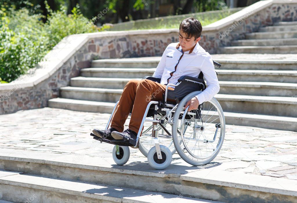 A young man in a wheelchair who can not descend the stairs.