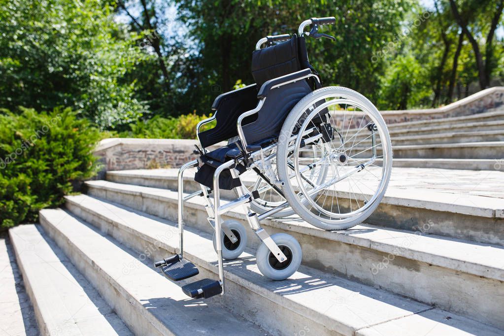 Wheelchair near the steps in a spring park.