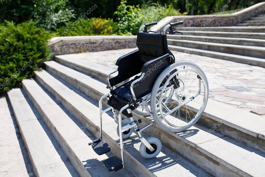 Wheelchair near the steps in a spring park.