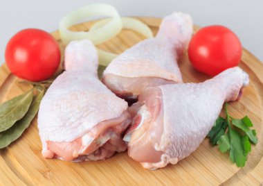 Beyaz arka planda çiğ tavuk bacağı.