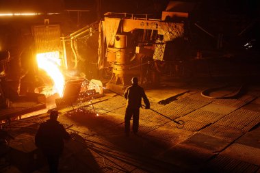 Çelik üretimi için bitki. Elektrikli bir eritme fırını. Fabrika işçisi metal için örnek alıyor.