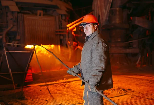 Anläggning för framställning av stål. En elektrisk smältugn. Fabriksarbetare tar prov för metall. — Stockfoto