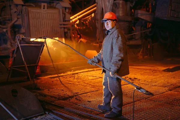 Anläggning för framställning av stål. En elektrisk smältugn. Fabriksarbetare tar prov för metall — Stockfoto