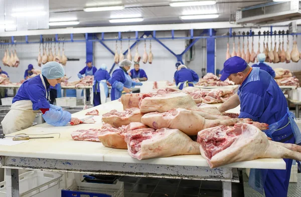 Cutting meat in slaughterhouse. The meat and sausage factory. — Stock Photo, Image