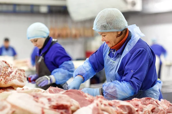 Cortar carne en el matadero. La fábrica de carne y salchichas . — Foto de Stock