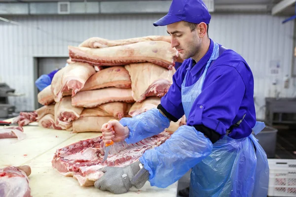 Cortar carne en el matadero. La fábrica de carne y salchichas . — Foto de Stock