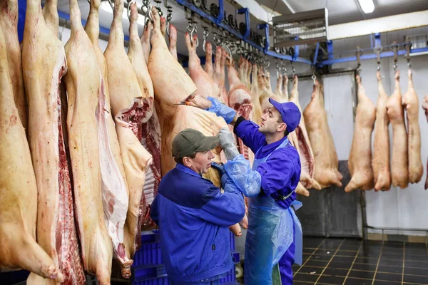 Butcher cutting pork at the meat manufacturing. — Stock Photo, Image