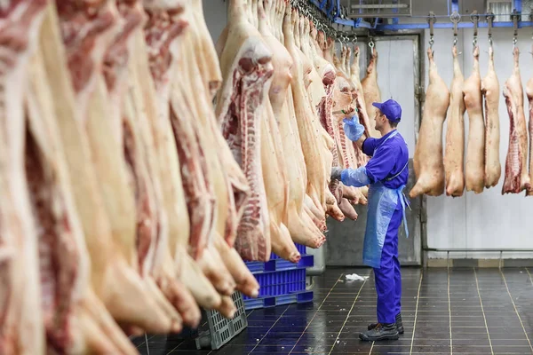 Carnicero cortando carne de cerdo en la fabricación de carne . — Foto de Stock