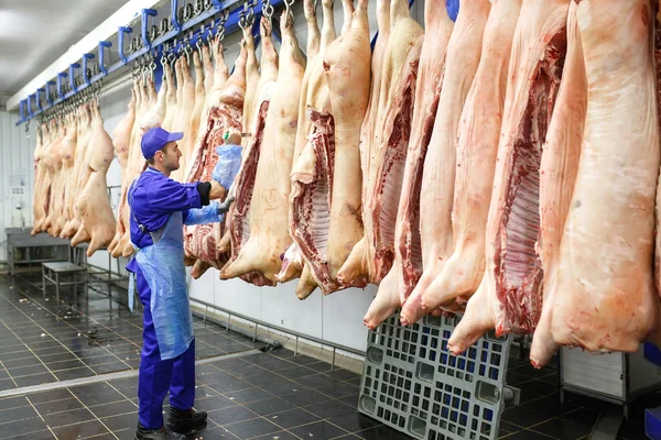 Butcher cutting pork at the meat manufacturing. — Stock Photo, Image