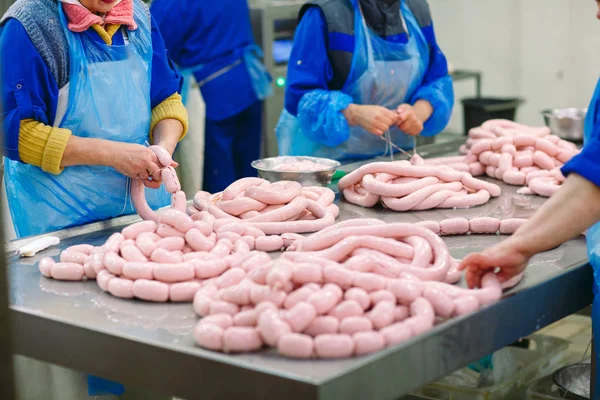 Butchers processing sausages at a meat factory. — Stock Photo, Image