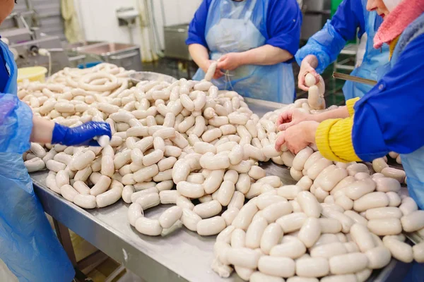 Butchers processing sausages at a meat factory. — Stock Photo, Image