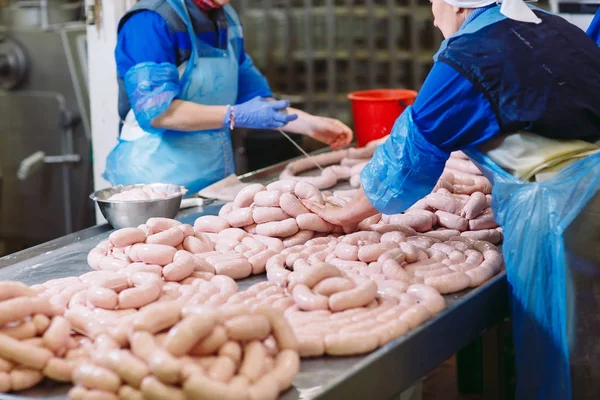 Bouchers transformant des saucisses dans une usine de viande . — Photo