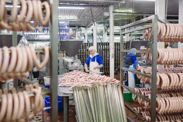 Мясники перерабатывают колбасы на мясной фабрике — стоковое фото