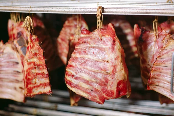 Fumar carne en el ahumadero de una fábrica de carne — Foto de Stock