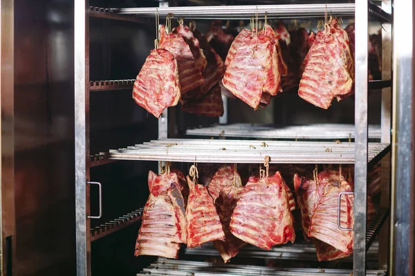 Fumar carne en el ahumadero de una fábrica de carne — Foto de Stock