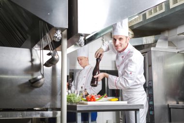 Şef restoranın mutfağında yemek hazırlıyor.