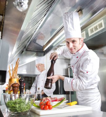 Şef restoranın mutfağında yemek hazırlıyor.