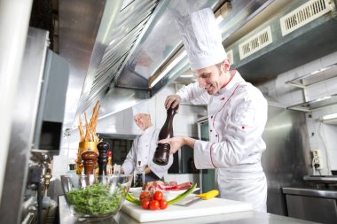 Şef restoranın mutfağında yemek hazırlıyor..