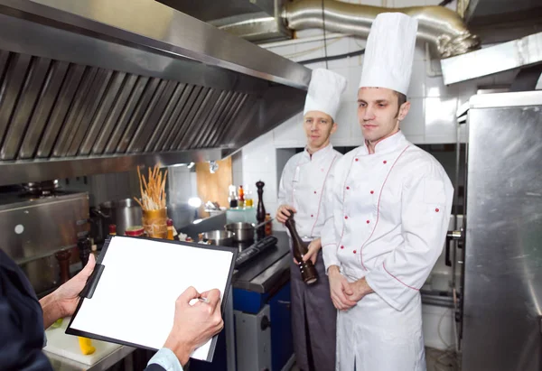 Restaurant manager briefing to his kitchen staff in the commercial kitchen — Stock Photo, Image