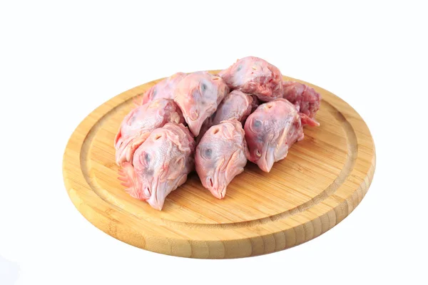 Raw chicken heads on a white background on a wooden board — Stock Photo, Image