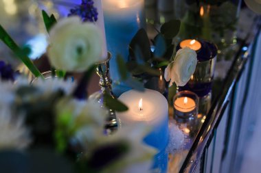 Akşamları bir masada mumlar ve çiçekler.